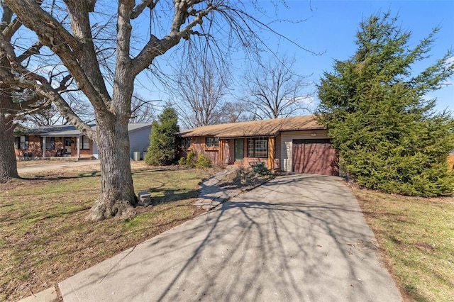 view of front of property featuring a front lawn, an attached garage, and driveway