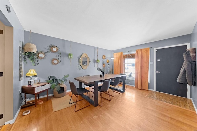 dining area with baseboards and light wood-style floors