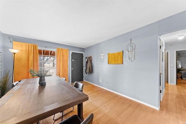 dining room featuring light wood-type flooring and baseboards