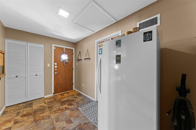 entryway with visible vents, stone finish flooring, and baseboards