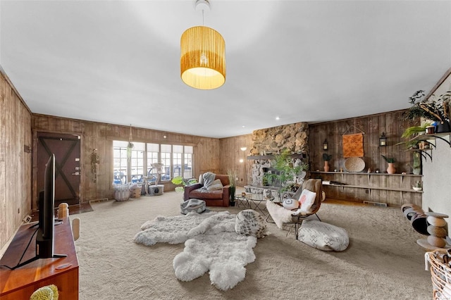 living room with wooden walls, a fireplace, visible vents, and carpet floors