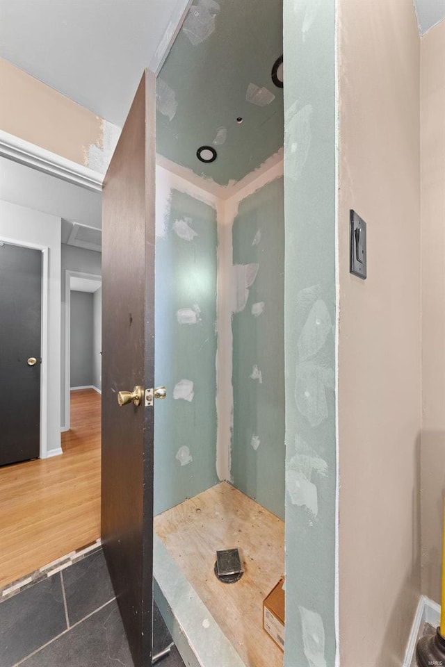 bathroom with tile patterned floors, baseboards, and walk in shower