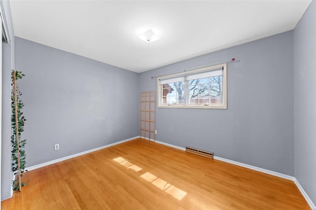 spare room featuring visible vents, baseboards, and light wood-style flooring