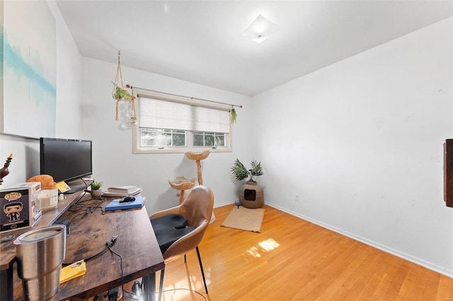 office space featuring baseboards and light wood-style floors