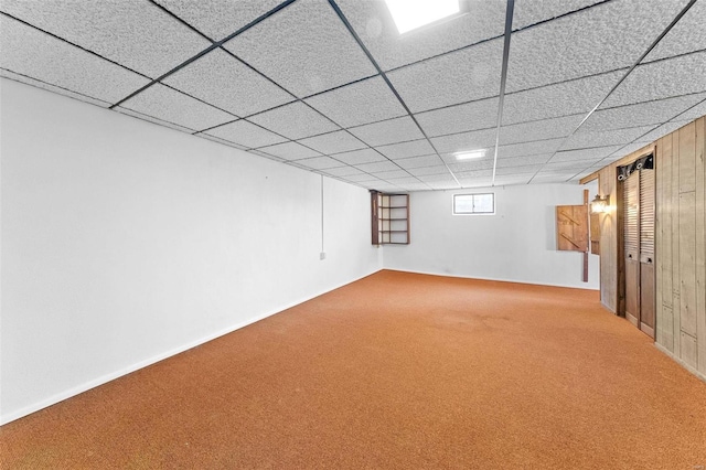 below grade area featuring a drop ceiling and carpet floors