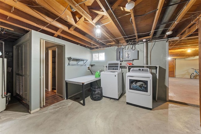 washroom with laundry area, electric panel, water heater, and washer and clothes dryer