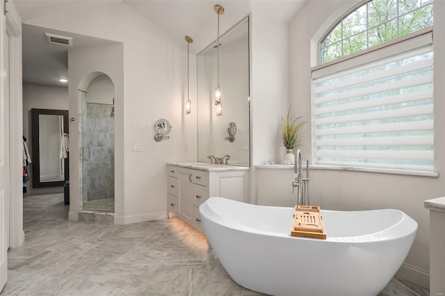 bathroom featuring vanity, visible vents, baseboards, a soaking tub, and a stall shower