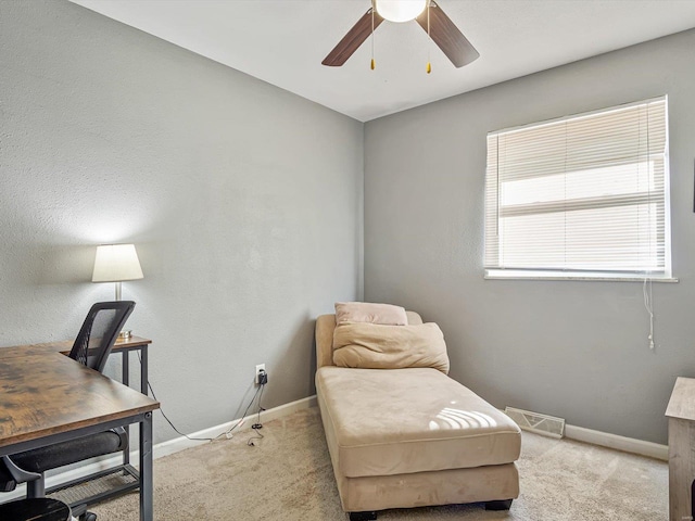 office space with carpet, a ceiling fan, visible vents, and baseboards