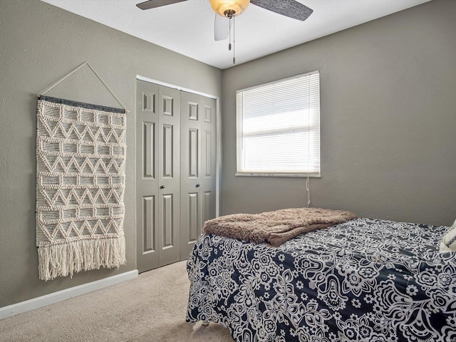 bedroom with a closet, carpet flooring, baseboards, and a textured wall