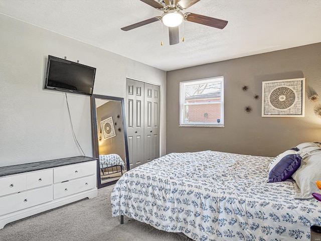 carpeted bedroom featuring a closet, a textured ceiling, and a ceiling fan