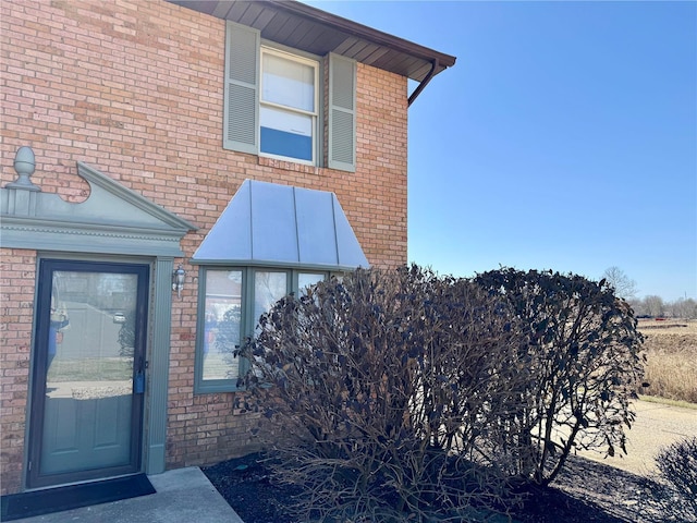 view of exterior entry featuring brick siding