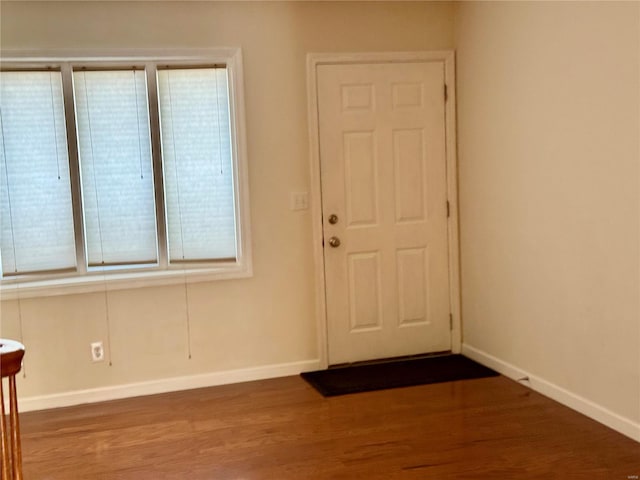 foyer featuring baseboards and wood finished floors