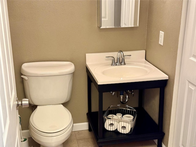 bathroom with baseboards, toilet, vanity, and tile patterned flooring