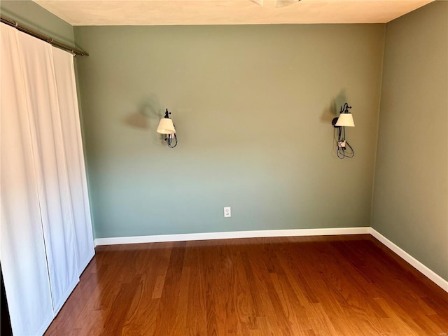 empty room with baseboards and wood finished floors