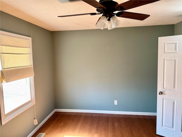 empty room featuring a ceiling fan, baseboards, and wood finished floors