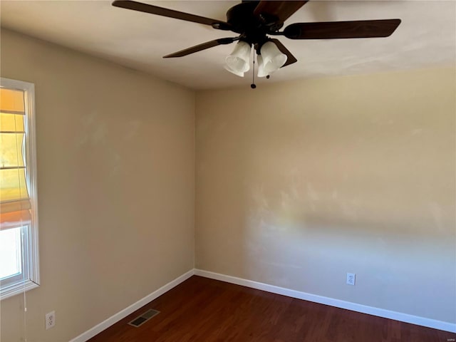 empty room with dark wood finished floors, visible vents, baseboards, and a healthy amount of sunlight