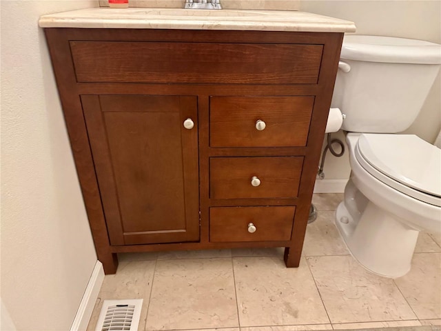 half bath with vanity, toilet, baseboards, and visible vents