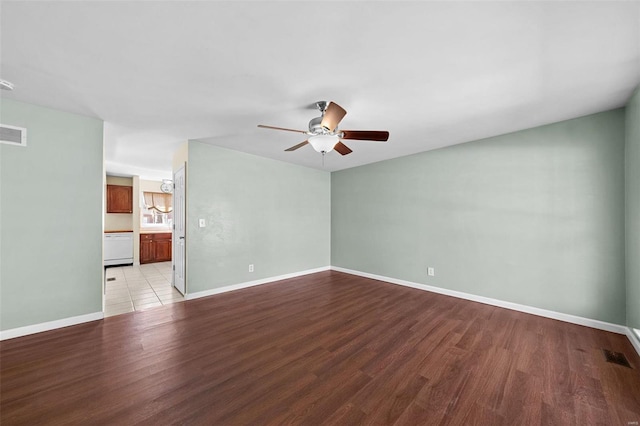 spare room with light wood-style flooring, visible vents, baseboards, and ceiling fan