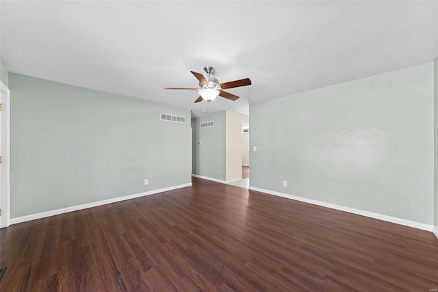 spare room with ceiling fan, visible vents, baseboards, and wood finished floors