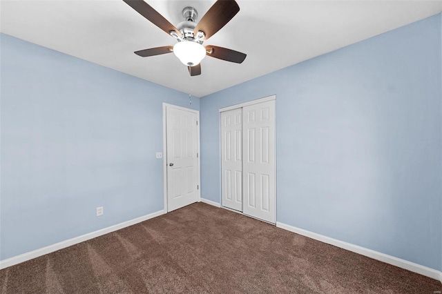 unfurnished bedroom with a closet, baseboards, ceiling fan, and dark carpet