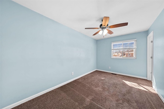 carpeted spare room featuring visible vents, baseboards, and ceiling fan