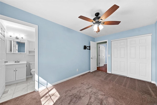 unfurnished bedroom with light colored carpet, baseboards, a closet, and ensuite bathroom