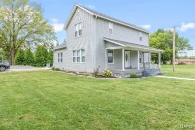 view of front of home featuring covered porch and a front lawn