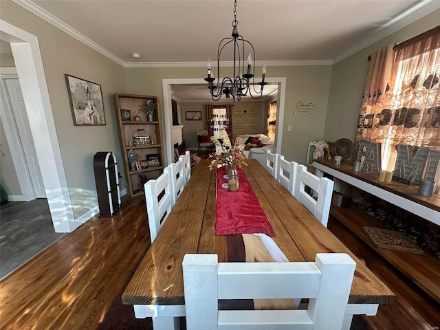 dining area featuring crown molding, baseboards, dark wood finished floors, and a notable chandelier