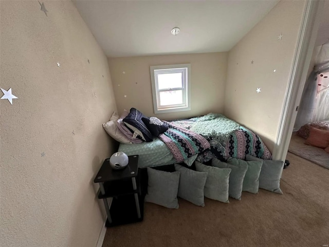 bedroom featuring carpet flooring and a textured wall