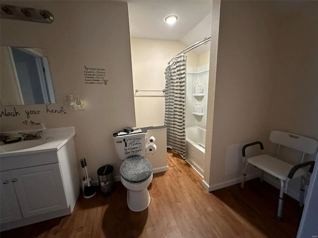 bathroom with toilet, wood finished floors, vanity, baseboards, and shower / bath combo with shower curtain