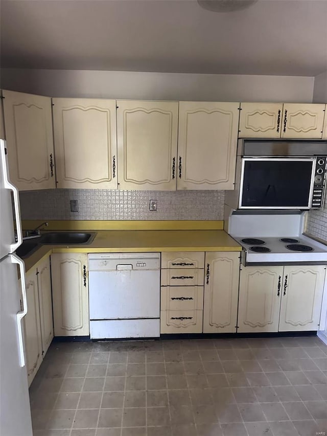 kitchen with white appliances, a sink, and tasteful backsplash