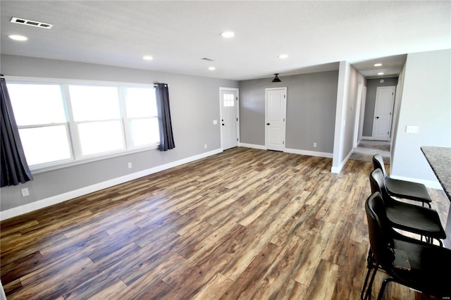 unfurnished living room featuring recessed lighting, wood finished floors, visible vents, and baseboards