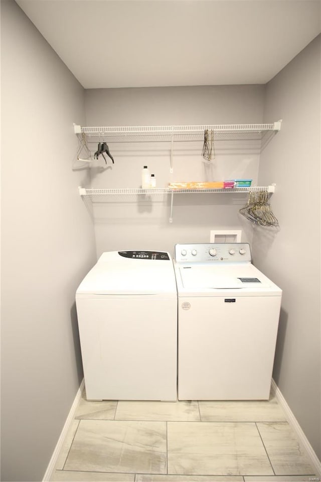 washroom with laundry area, baseboards, marble finish floor, and washer and clothes dryer