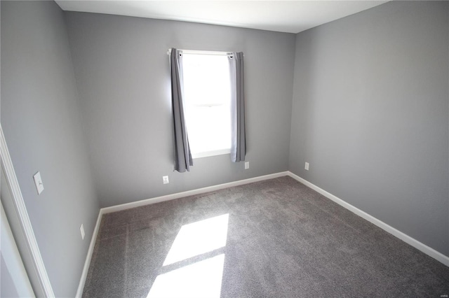 spare room featuring carpet flooring and baseboards