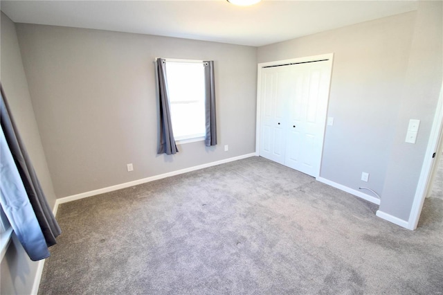 unfurnished bedroom with a closet, baseboards, and carpet flooring