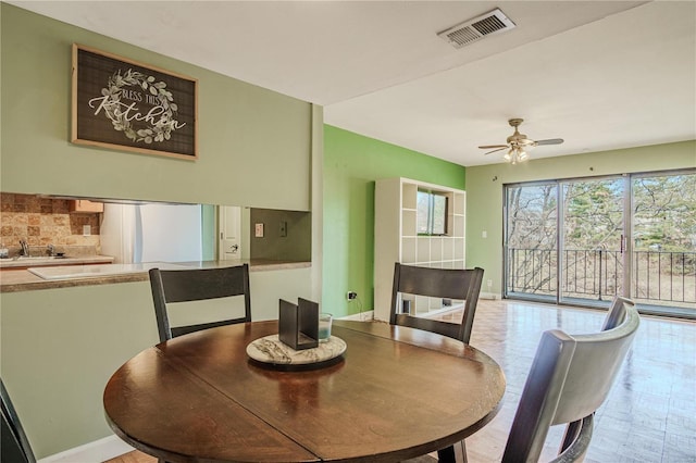 dining area featuring visible vents, ceiling fan, and baseboards