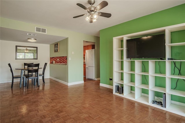 unfurnished dining area featuring visible vents, baseboards, and a ceiling fan