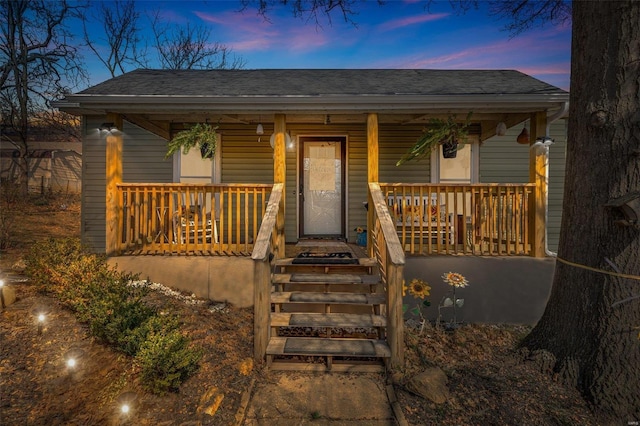 view of front of property featuring roof with shingles and a porch