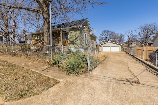 view of property exterior featuring a fenced front yard, a garage, and an outdoor structure