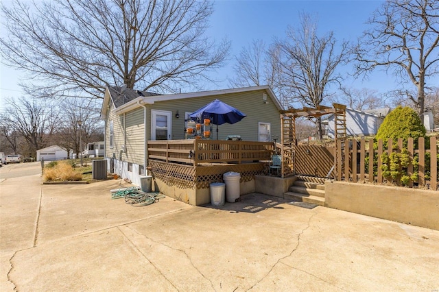 view of side of property featuring a wooden deck, fence, cooling unit, and a patio area