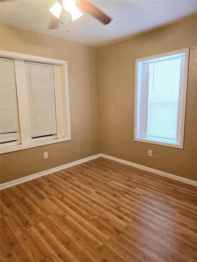 unfurnished room with wood finished floors, baseboards, and ceiling fan