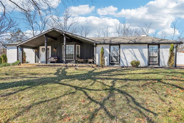 mid-century modern home with brick siding, board and batten siding, and a front yard