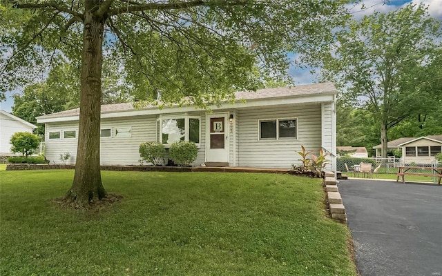 ranch-style house with a front lawn and fence