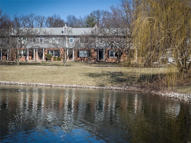 rear view of property with a yard and a water view