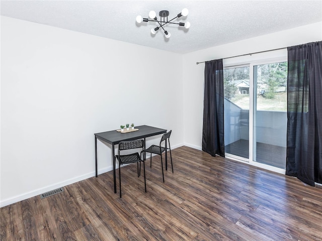 dining space with a chandelier, visible vents, a textured ceiling, and wood finished floors