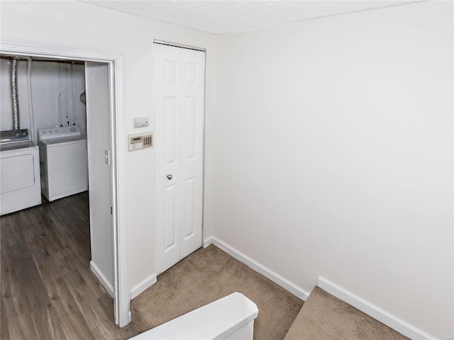 interior space with baseboards, laundry area, wood finished floors, independent washer and dryer, and a textured ceiling