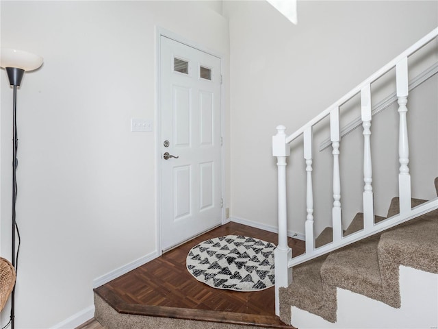 foyer entrance with visible vents, baseboards, and stairs