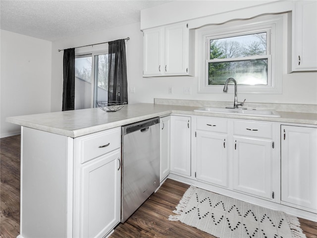 kitchen featuring a sink, stainless steel dishwasher, a peninsula, and dark wood-style floors