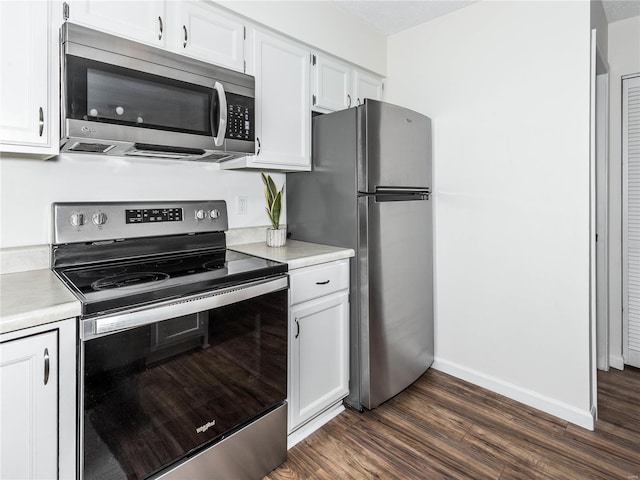 kitchen featuring dark wood-style floors, appliances with stainless steel finishes, white cabinetry, and light countertops