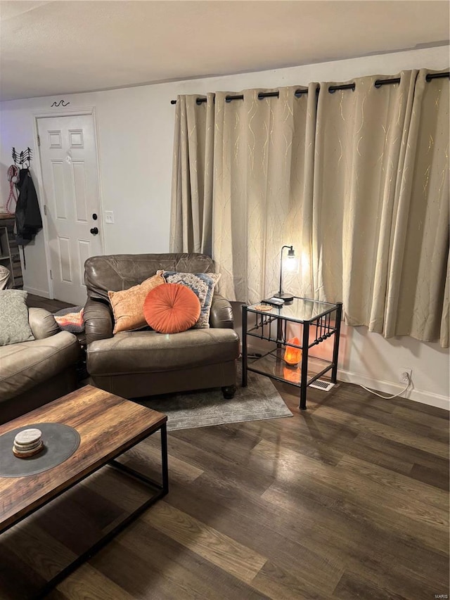 living room with dark wood-type flooring and baseboards